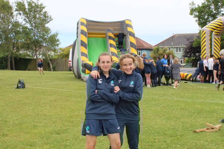 Hannah Macdonald and Sapphire Palfrey Smith enjoying the afternoon of inflatables, bungee runs and ice-cream to celebrate achieving a 20-day attendance streak at Dawlish College.